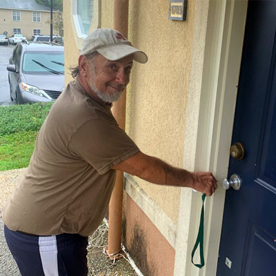 man smiling and getting ready to open a door