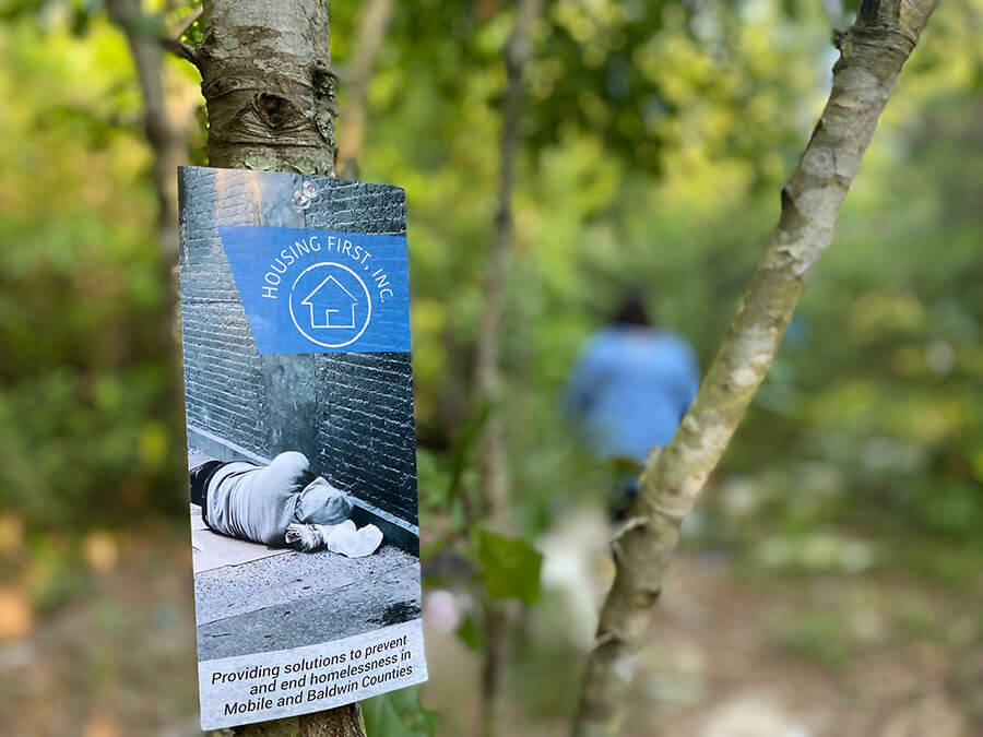 Housing First, Inc Brochure on a tree in the woods